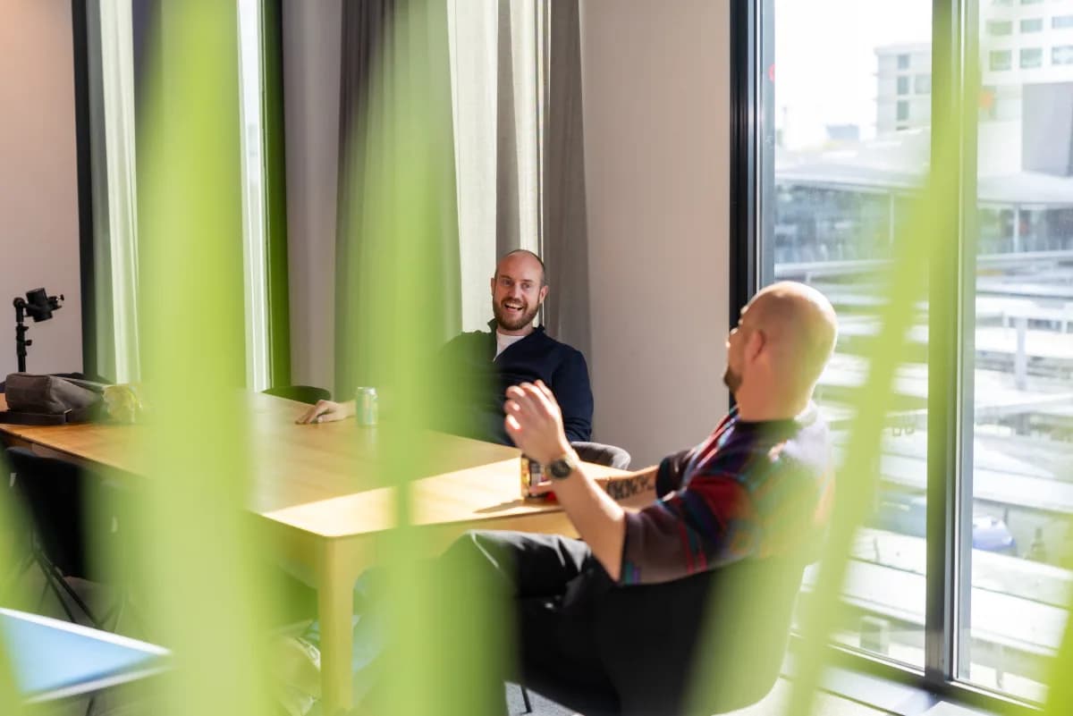 Collega's in gesprek bij het raam op kantoor